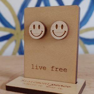 smiley face stud earrings on a wooden display